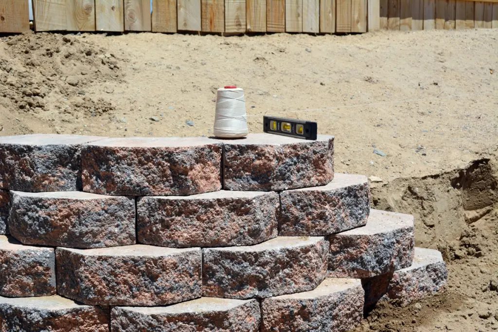 Secure top-row blocks: How To Build a Retaining Wall on A Slope